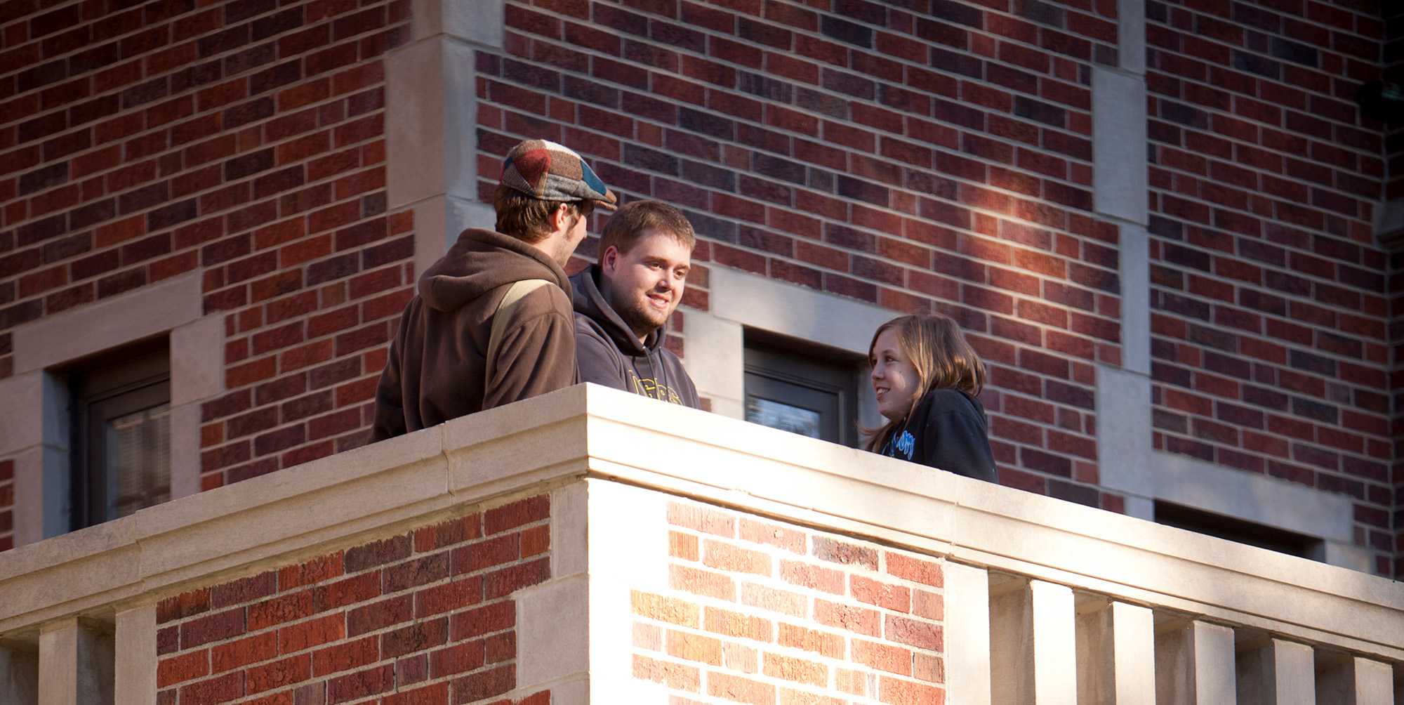 Students talking on a balcony at Fees Hall