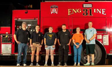 Doane faculty, students and alumni stand in front of a fire truck